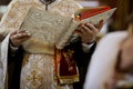 Details of an Orthodox priest reading from the Holy Bible during an Orthodox Baptism