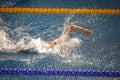 Details with a professional female athlete swimming in an olympic swimming pool