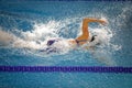 Details with a professional female athlete swimming in an olympic swimming pool