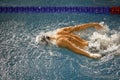 Details with a professional male athlete swimming in an olympic swimming pool butterfly style