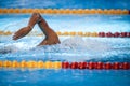 Details with a professional male athlete swimming in an olympic swimming pool freestyle