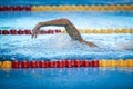 Details with a professional male athlete swimming in an olympic swimming pool freestyle