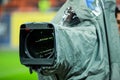 Details of a professional television camera, with rain cover, live broadcasting a soccer game