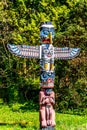 A section of the the colorful `Thunderbird House Post Totem Pole` depicting a Grizzly bear holding a human H