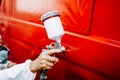 Details of spray gun in automotive industry. painting a red car Royalty Free Stock Photo