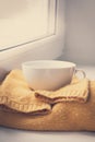 Details of still life in the home interior. Sweater, cup, wool, cozy, book, candle. Moody. Cosy autumn winter concept. Royalty Free Stock Photo