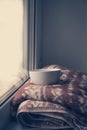 Details of still life in the home interior. Sweater, cup, wool, cozy, book, candle. Moody. Cosy autumn winter concept. Royalty Free Stock Photo