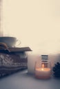 Details of still life in the home interior. Sweater, cup, wool, cozy, book, candle. Moody. Cosy autumn winter concept. Royalty Free Stock Photo