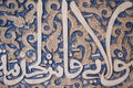 Details of stucco decoration with an Arabic writings painted in blue on the Palaces walls in Alhambra complex, Granada, Andalusia