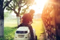 details during sunset hour. Man working on ride-on lawn mower