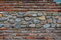 Details and texture of ancient Roman wall made of red bricks and colorful stones. Royalty Free Stock Photo