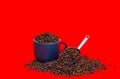 Coffee bean scoop and cup filled with coffee beans on red background Royalty Free Stock Photo