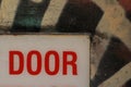 details of a warning sign on a back entry door in a side alley covered in graffiti, detail showing only the word \