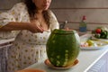 A watermelon and cropped view of a housewife cutting slices of ripe organic juicy berry, standing at the kitchen counter Royalty Free Stock Photo