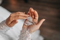 Details. Wedding accessories. Bride holds crystal earrings in hands, cropped photo. Royalty Free Stock Photo