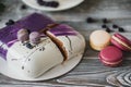 Details of a wedding or a birthday purple cake, in studio on wooden background. Purple small macarons as main decoration Royalty Free Stock Photo