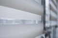 Details of white fabric roller blinds on the white plastic window in the living room. Close up on roll curtains indoor. Royalty Free Stock Photo