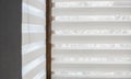 Details of white fabric roller blinds on the plastic window with wood texture in the living room. Royalty Free Stock Photo