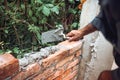 Details of worker, bricklayer placing and adjusting bricks with mortar. Professional construction worker building exterior walls