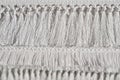 Details of woven white rug, light fringe texture.