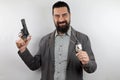 Detective with beard smiling showing police badge holds the gun with his arm up. Royalty Free Stock Photo