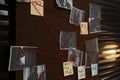 Detective board with crime scene photos, stickers, clues and red thread on wall, closeup