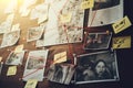 Detective board with photos of suspected criminals, crime scenes and evidence with red threads, selective focus