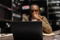 Detective conducting investigation using laptop in dark office Royalty Free Stock Photo