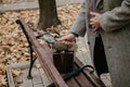 Detective hand holds magnifier over wooden park bench