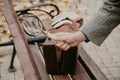 Detective hand holds magnifier over wooden park bench
