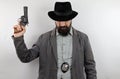 Detective with hat covering the eyes and police badge holding gun with the arm raised. Royalty Free Stock Photo