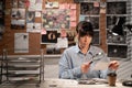 Detective holding magnifying glass in front of photos from murder scene while working at desk in office Royalty Free Stock Photo