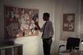 Detective looking at evidence board in office Royalty Free Stock Photo