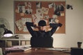 Detective looking at evidence board in office, back view