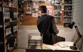 Detective looking at investigation board in office, searching for solution, back view Royalty Free Stock Photo