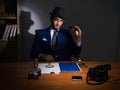 Detective sitting in dark room in vintage concept Royalty Free Stock Photo
