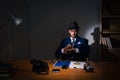 The detective sitting in dark room in vintage concept Royalty Free Stock Photo