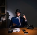 Detective sitting in dark room in vintage concept Royalty Free Stock Photo