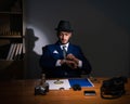 Detective sitting in dark room in vintage concept Royalty Free Stock Photo