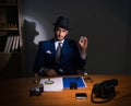 Detective sitting in dark room in vintage concept Royalty Free Stock Photo