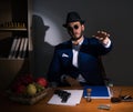 Detective sitting in dark room in vintage concept Royalty Free Stock Photo