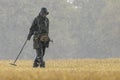 Metal detectorist searching in the rain