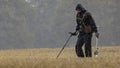 Metal detectorist searching in the rain