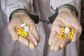The detention of workers in the illicit manufacture of medicines. Hands holding pills are handcuffed