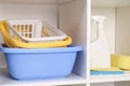 Detergent, baskets and different cleaning tools on shelves Royalty Free Stock Photo