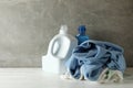 Detergent and crumpled towels against gray background