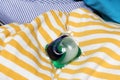 Detergent pods with a means for washing and removing stains lies on a pile of laundry. The concept of cleaning clothes with gel Royalty Free Stock Photo