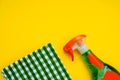 Detergent for washing glasses and a green napkin on a yellow background. Place for text. Cleaning. Purity. Flat lay