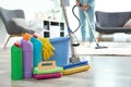 Detergents, bucket and mop on floor with janitor vacuuming carpet Royalty Free Stock Photo