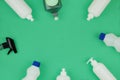 Detergents in plastic bottles. Cleaning accessories. Flat lay of white cleaning supplies on green background. Top view Royalty Free Stock Photo